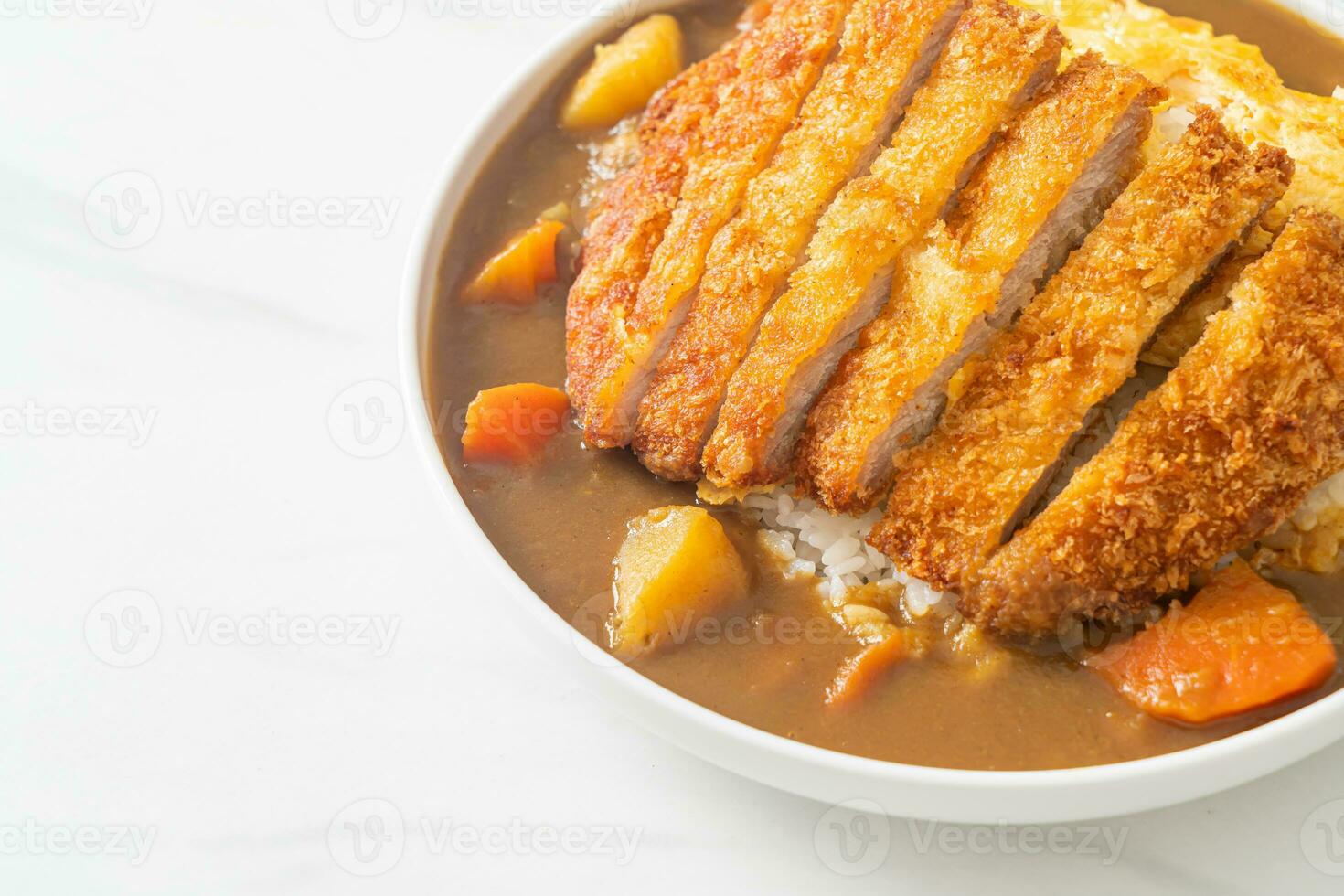 Curryreis mit gebratenem Schweinekotelett und cremigem Omelett foto