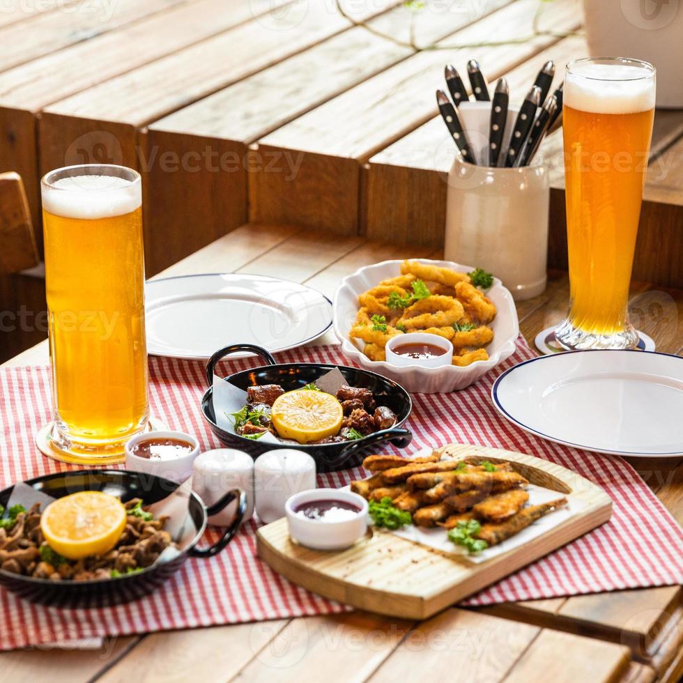leckeres Fleischmahlzeit-Roulette mit Zitronen-Sprotte und Bier auf dem Restauranttisch foto