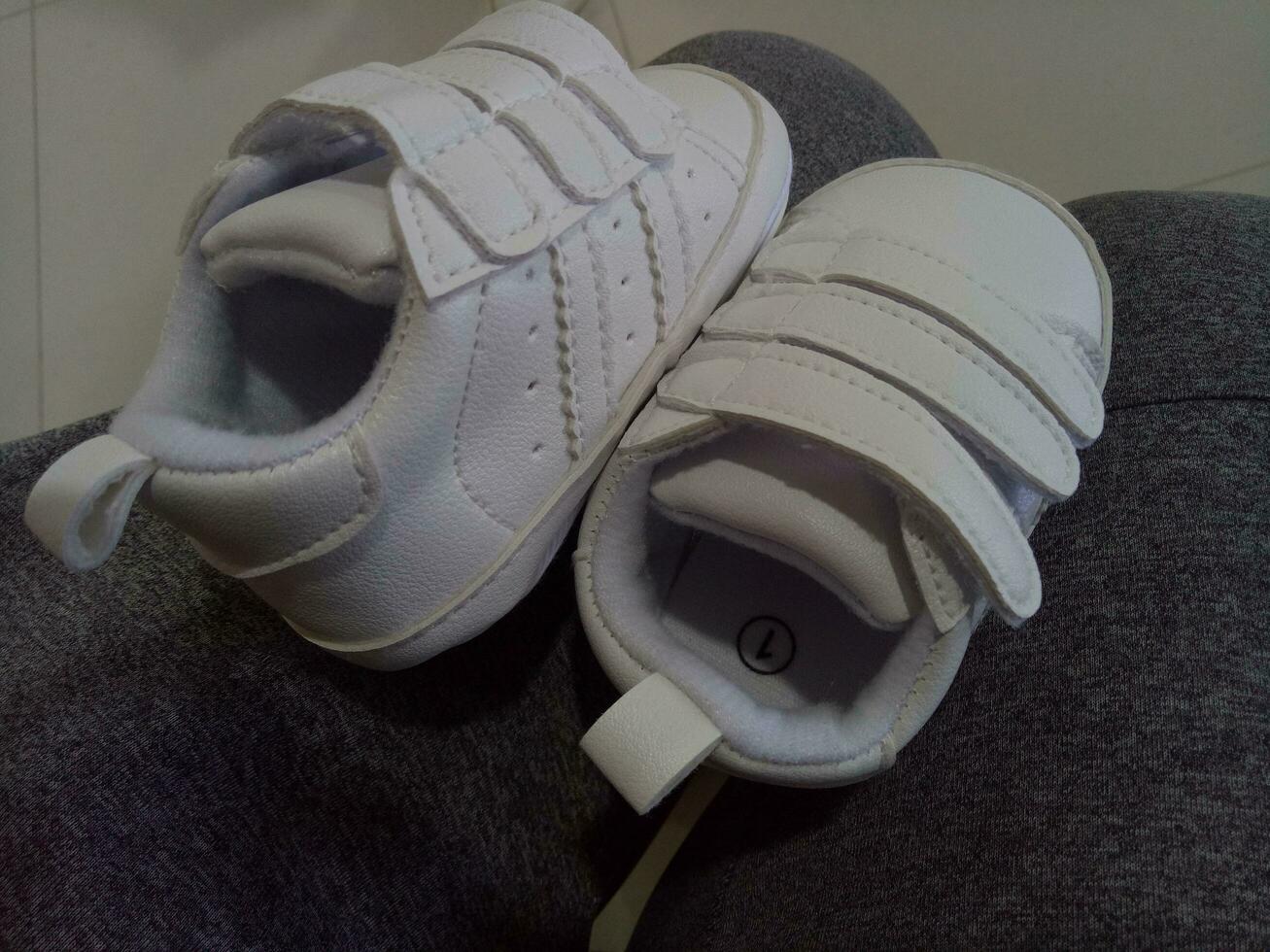 Foto von ein süß wenig Weiß Baby Schuh mit verdreifachen Klebstoff