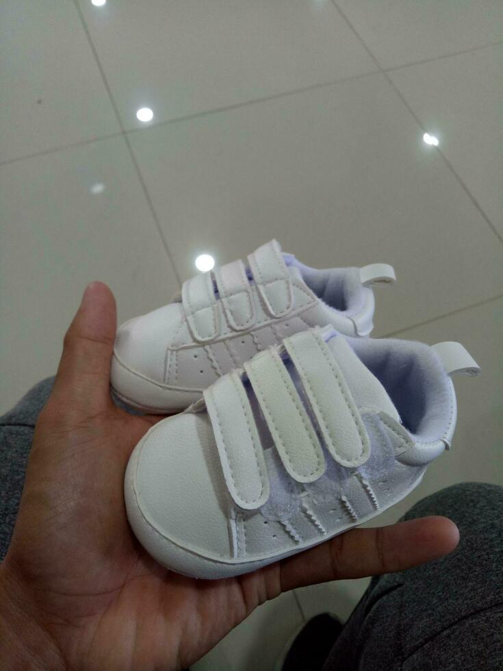 Foto von ein süß wenig Weiß Baby Schuh mit verdreifachen Klebstoff