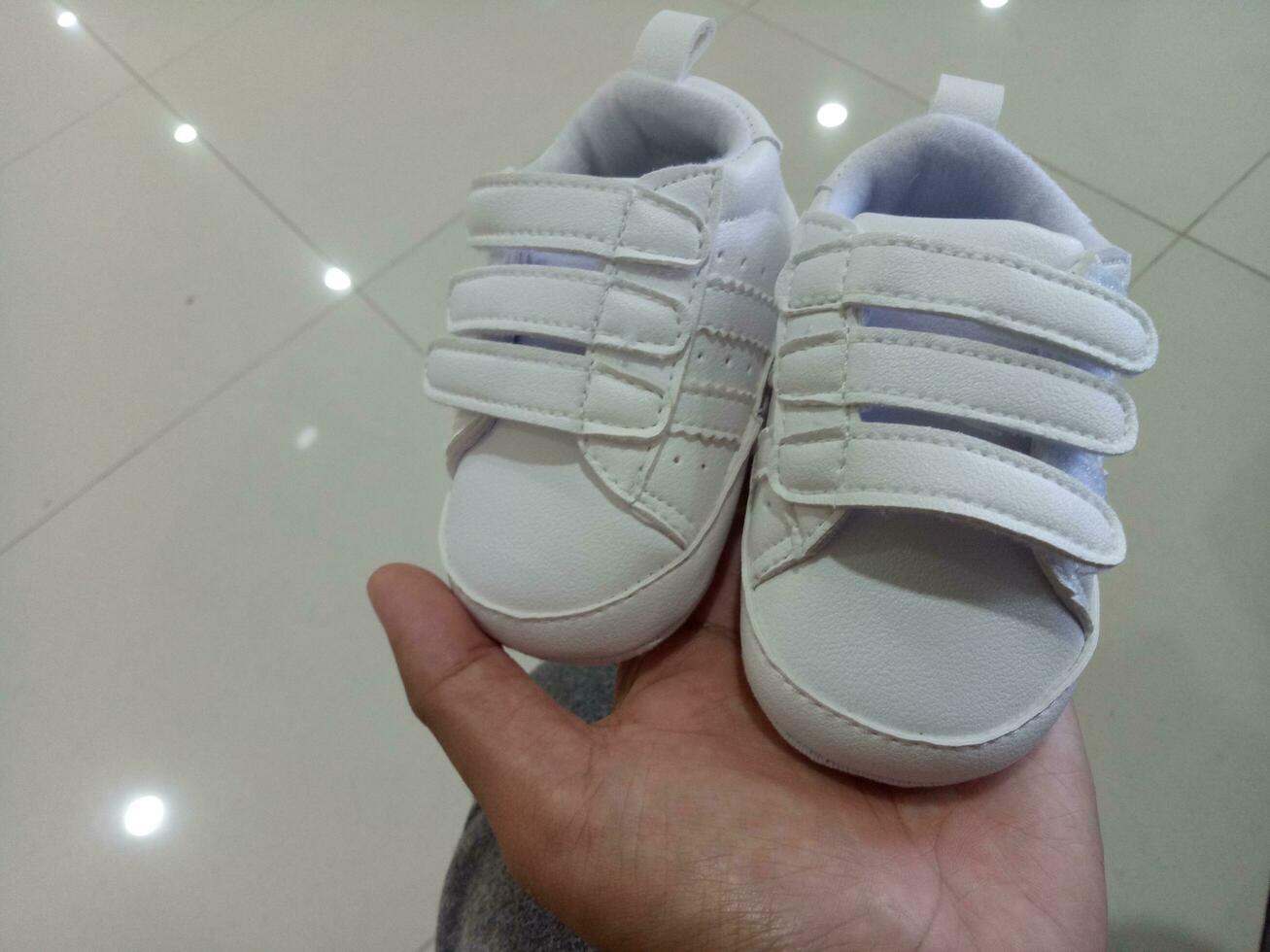 Foto von ein süß wenig Weiß Baby Schuh mit verdreifachen Klebstoff