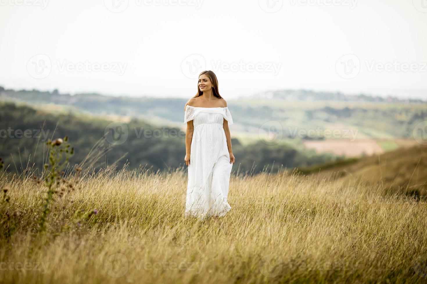 junge schwangere Frau auf dem Feld foto