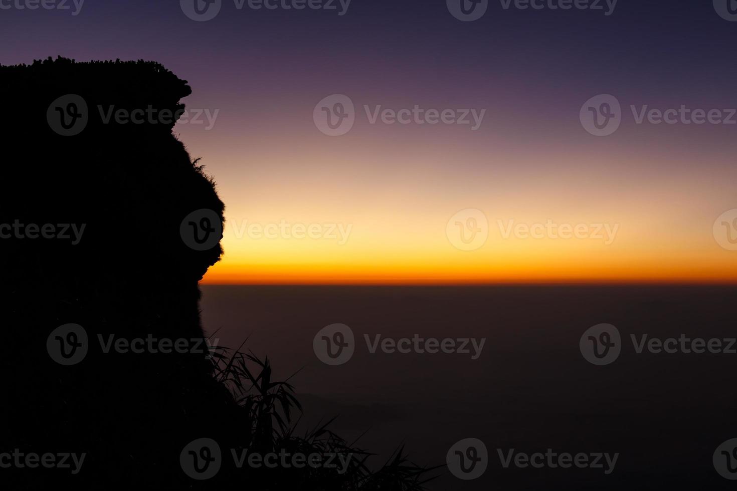 Sonnenaufgang und Nebelmeer bei Phu Chi Fa in der Silhouette des frühen Morgens und Touristen an der Spitze des Hügels foto