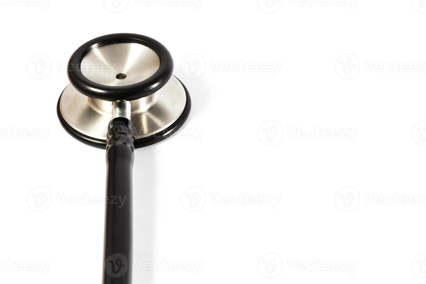 der Kopf des schwarzen Stethoskops auf der linken Seite und der leere Bereich rechts auf weißem Hintergrund foto