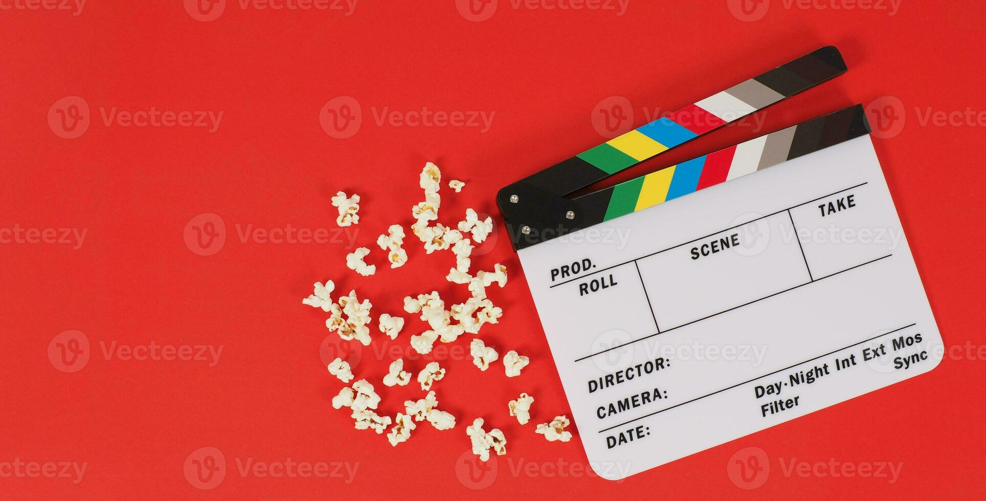 Filmklappe oder Filmtafel und Popcorn auf rotem Hintergrund. foto