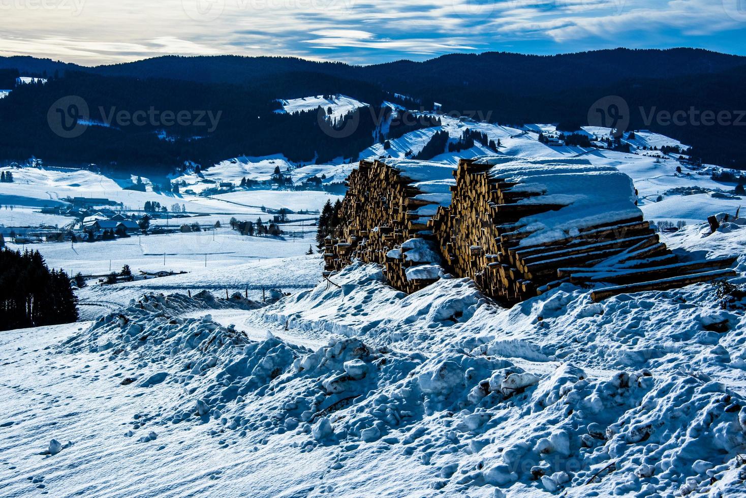 Holzscheite unter dem Schnee gestapelt foto