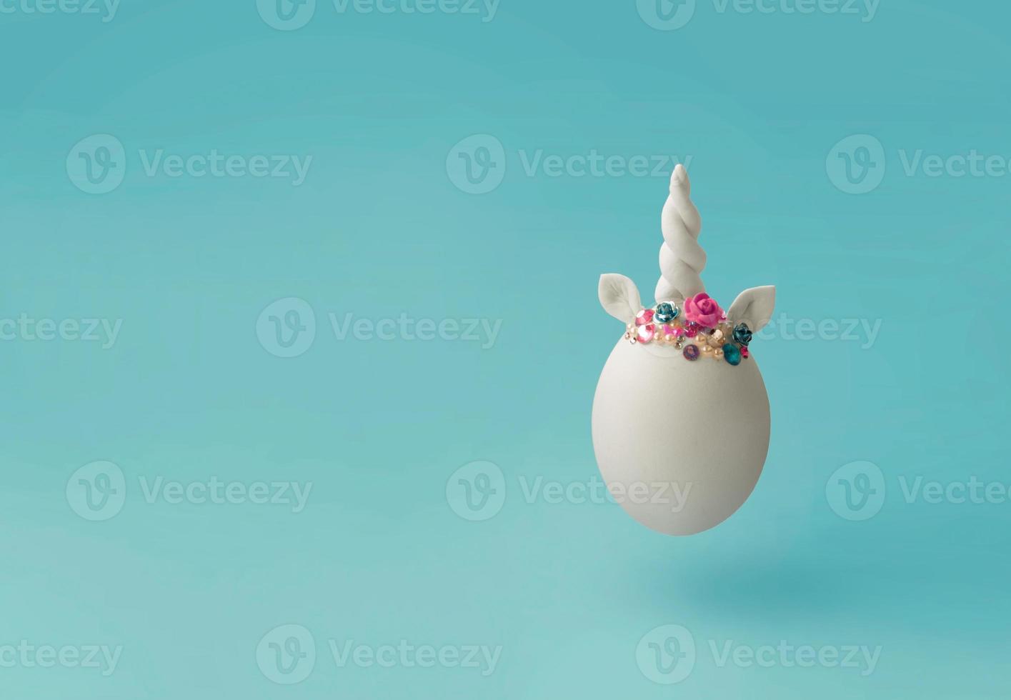 einzelnes weißes Ei mit kreativem minimalem Osterhintergrund des Einhornhorns mit Kopienraum foto