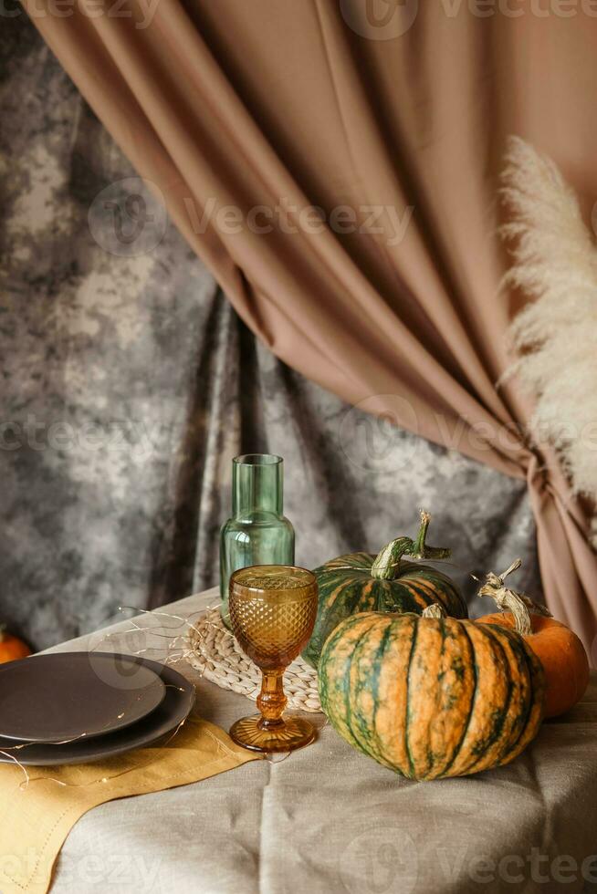 Herbst Innere. ein Tabelle bedeckt mit Teller, Kürbisse, Stuhl, beiläufig Anordnung von japanisch Pampas Gras. Innere im das Foto Studio.