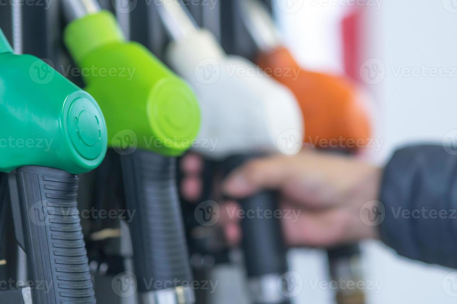 Kraftstoffpumpendüsen für verschiedene Kraftstoffarten in einer Tankstelle foto
