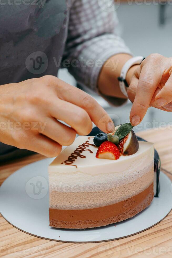 ein Stück von Schokolade Kuchen im das schneiden. Vorbereitung von Mousse Kuchen beim ein kulinarisch Meister Klasse. Kochen beim heim, hausgemacht Essen foto