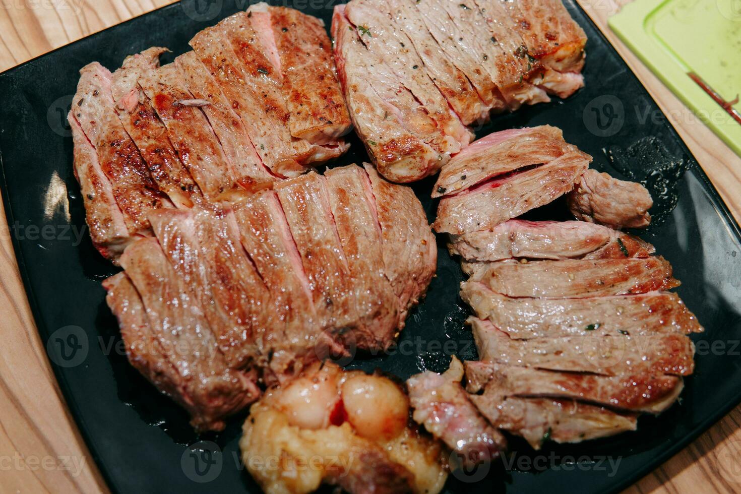 Rindfleisch Steak mit Grüns auf ein schwarz Platte. Steak mit Basilikum gekocht im das kulinarisch Meister Klasse foto