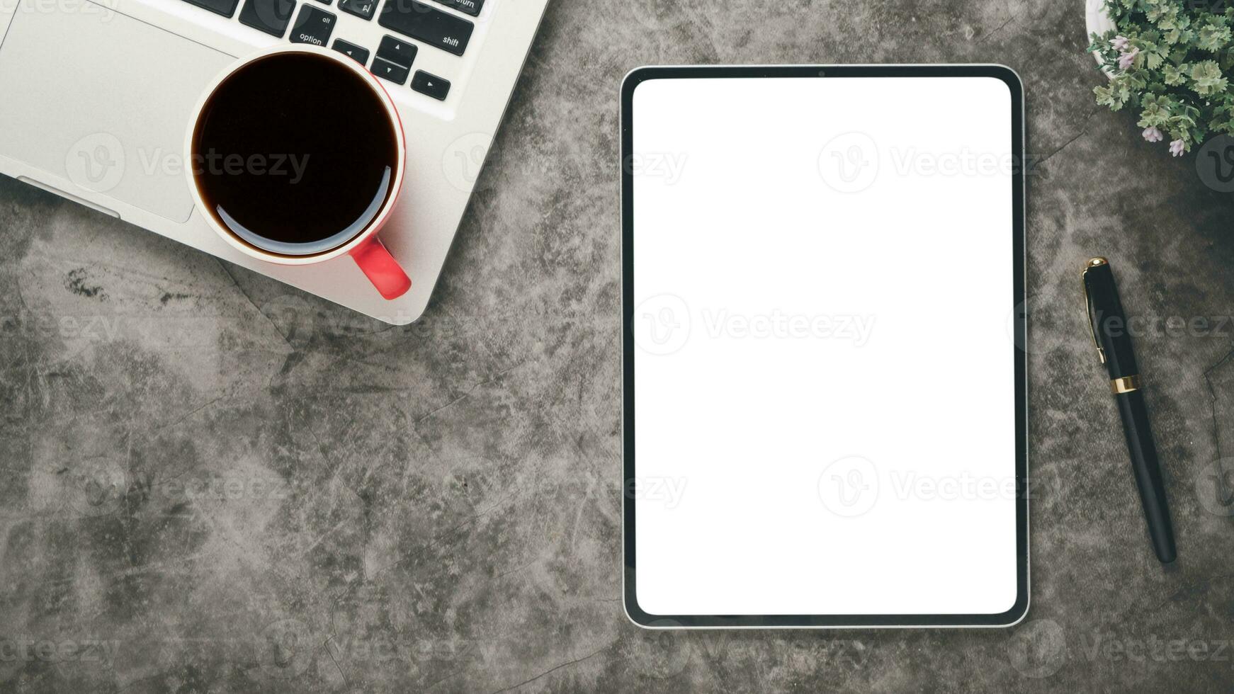 dunkel Büro Schreibtisch Arbeitsplatz mit leer Bildschirm Tablette, Laptop, Stift, Notizbuch und Tasse von Kaffee, oben Aussicht eben legen mit Kopieren Raum. foto