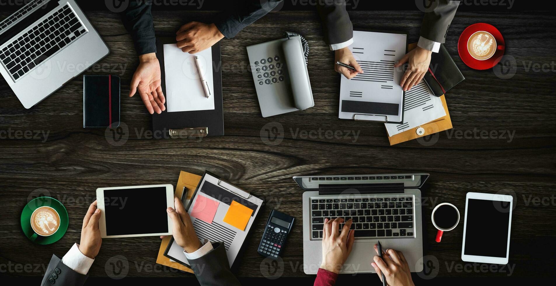 Draufsicht der Geschäftsgruppe multiethnischer vielbeschäftigter Menschen, die sich in einem modernen Büro mit Laptop-Computer, Smartphone, Tablet, Kaffee und Dokument auf dem Tisch treffen. foto