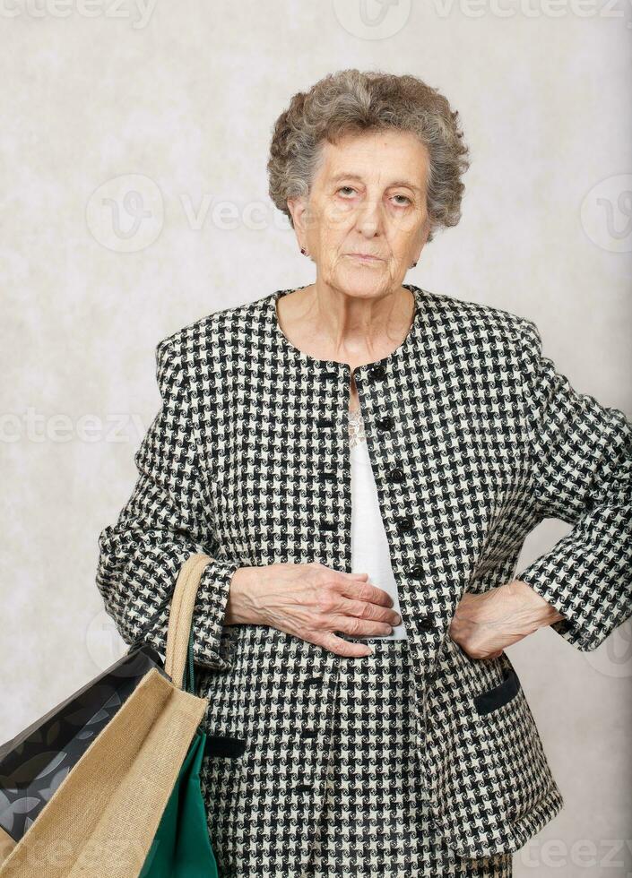 alt Frau mit Einkaufen Taschen foto