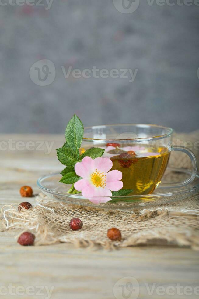 Rose Hüfte Kräuter- Tee auf ein hölzern Oberfläche. kostenlos Text. foto