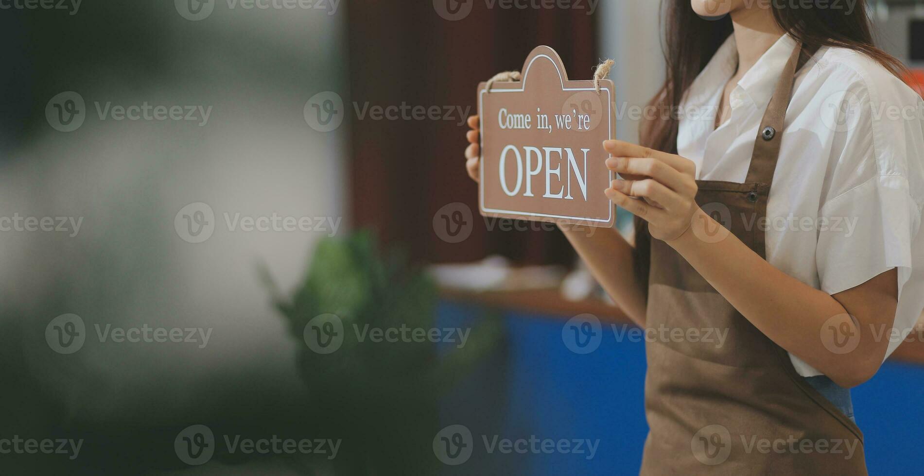 herzlich willkommen. offen. Barista, Kellnerin Frau drehen öffnen Zeichen Tafel auf Glas Tür im modern Cafe Kaffee Geschäft bereit zu Service, Cafe Restaurant, Verkauf speichern, klein Geschäft Eigentümer, Essen und trinken Konzept foto