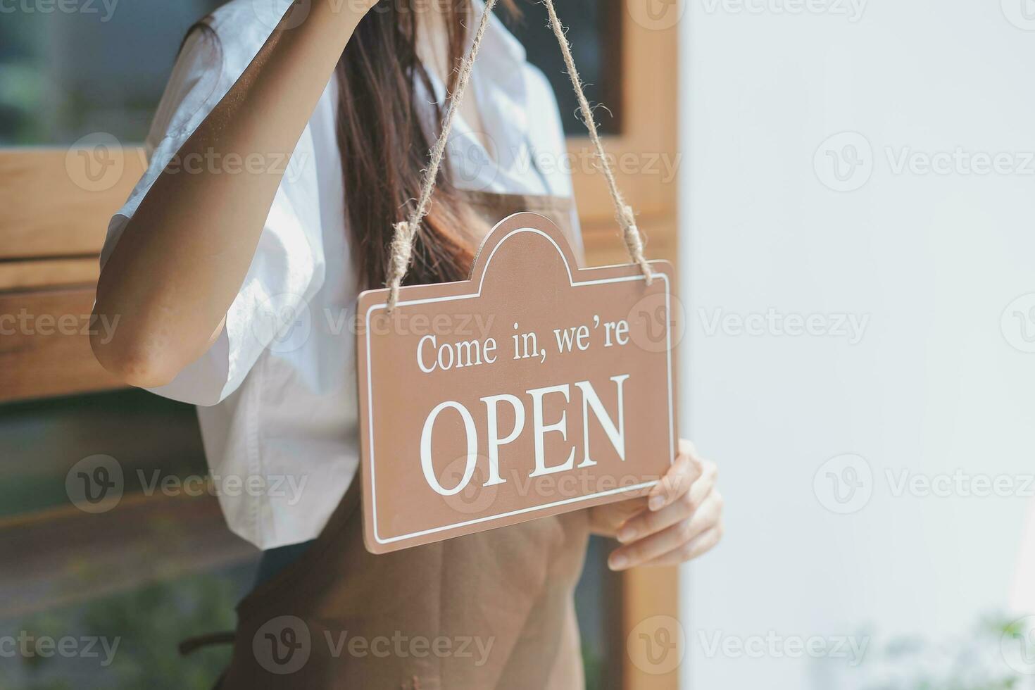 jung Unternehmer halten öffnen Zeichen auf Glas Tür beim Cafe foto