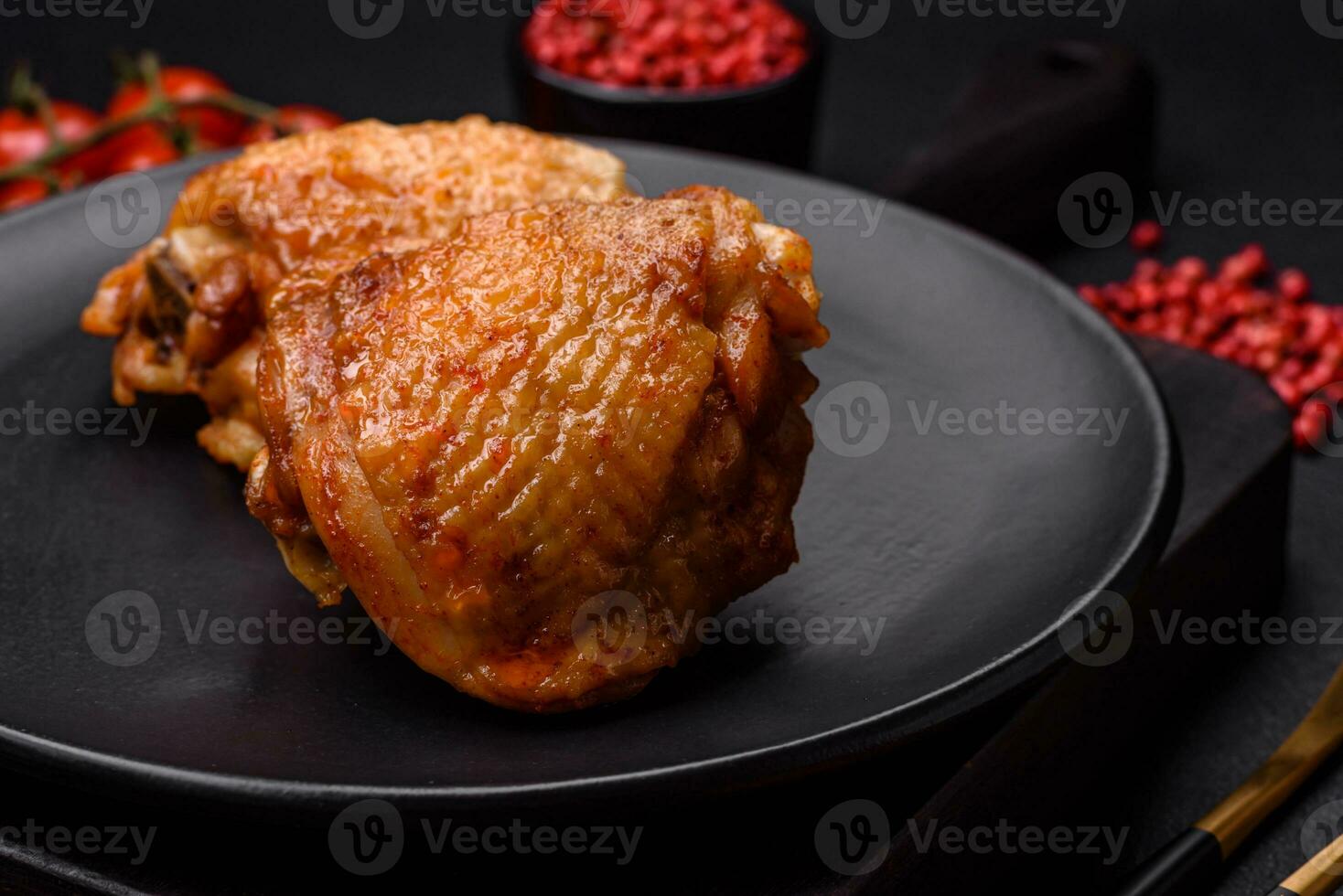 köstlich saftig Hähnchen Oberschenkel gebacken mit Salz, Gewürze und Kräuter im ein Keramik Teller foto