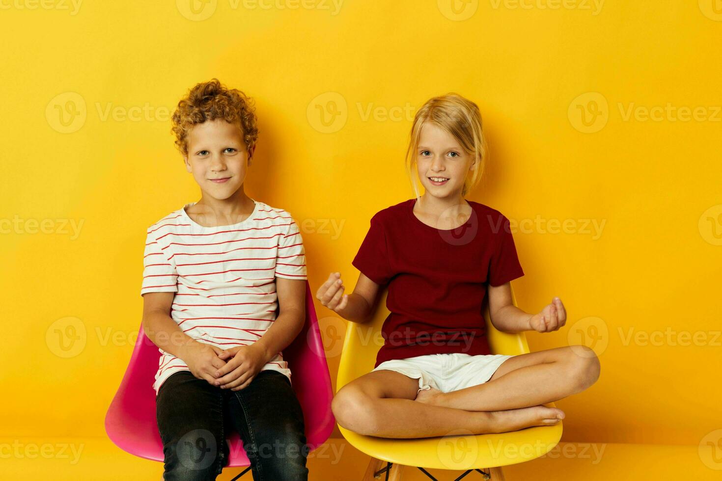 klein Kinder Kindheit Sitzung auf Stühle zusammen auf farbig Hintergrund foto