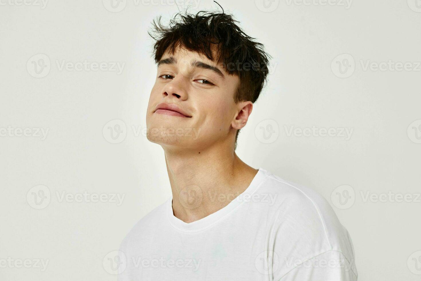 Porträt von ein jung Mann modern Jugend Stil Weiß T-Shirt tätowieren auf das Arm Licht Hintergrund unverändert foto