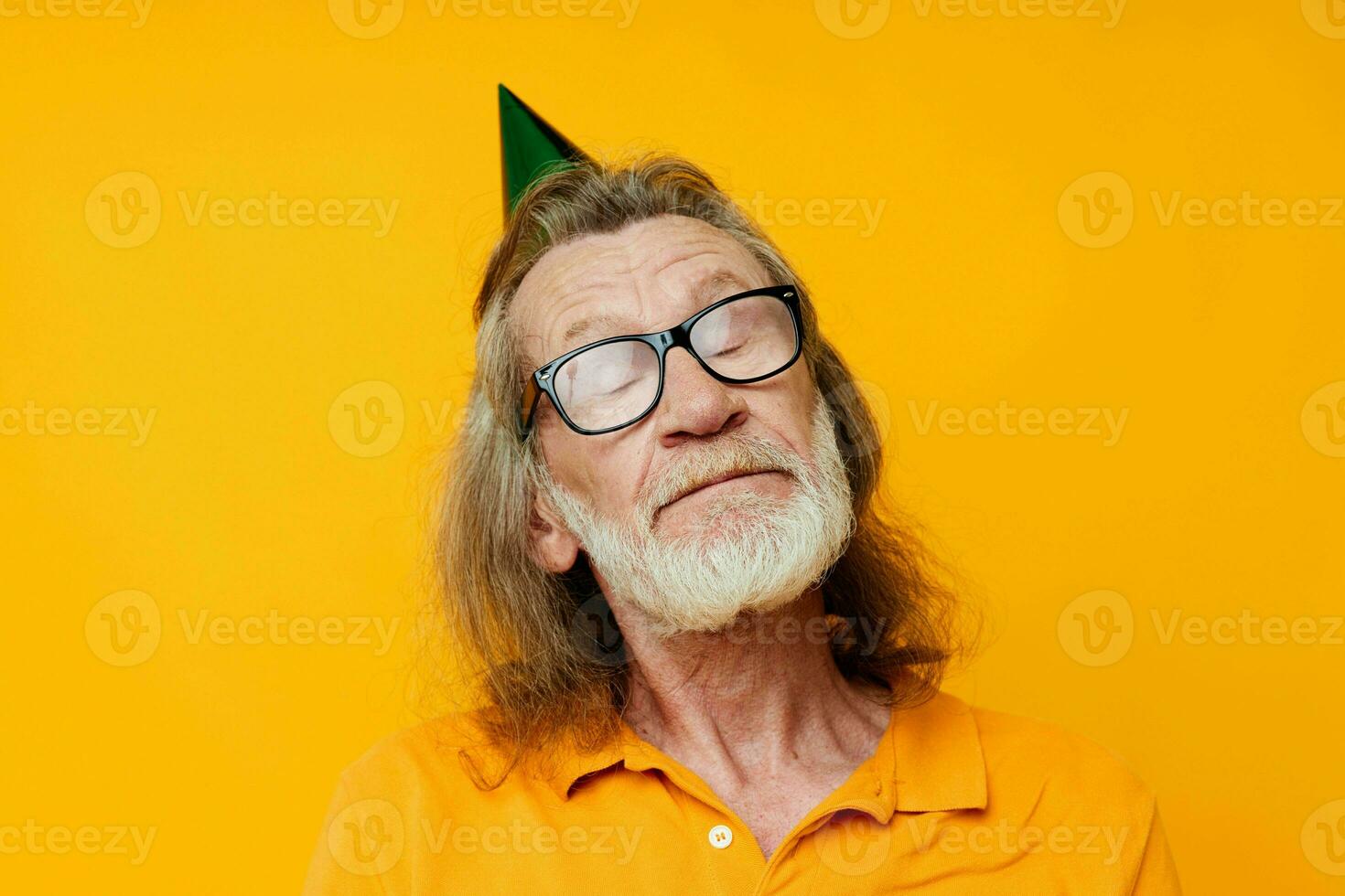 Senior grauhaarig Mann im ein Gelb T-Shirt mit ein Deckel auf seine Kopf Spaß abgeschnitten Aussicht foto