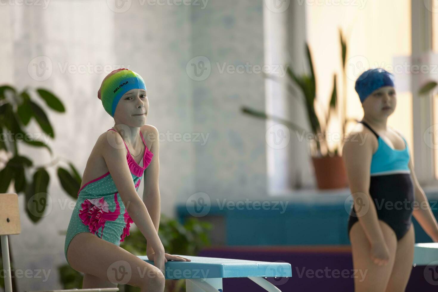 Mädchen im ein Badeanzug und ein Schwimmen Deckel mit Brille im das Sport Schwimmbad. foto