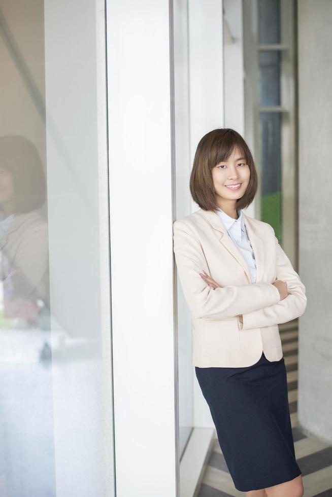 attraktive asiatische Geschäftsfrau, die außerhalb des Büros lächelt foto