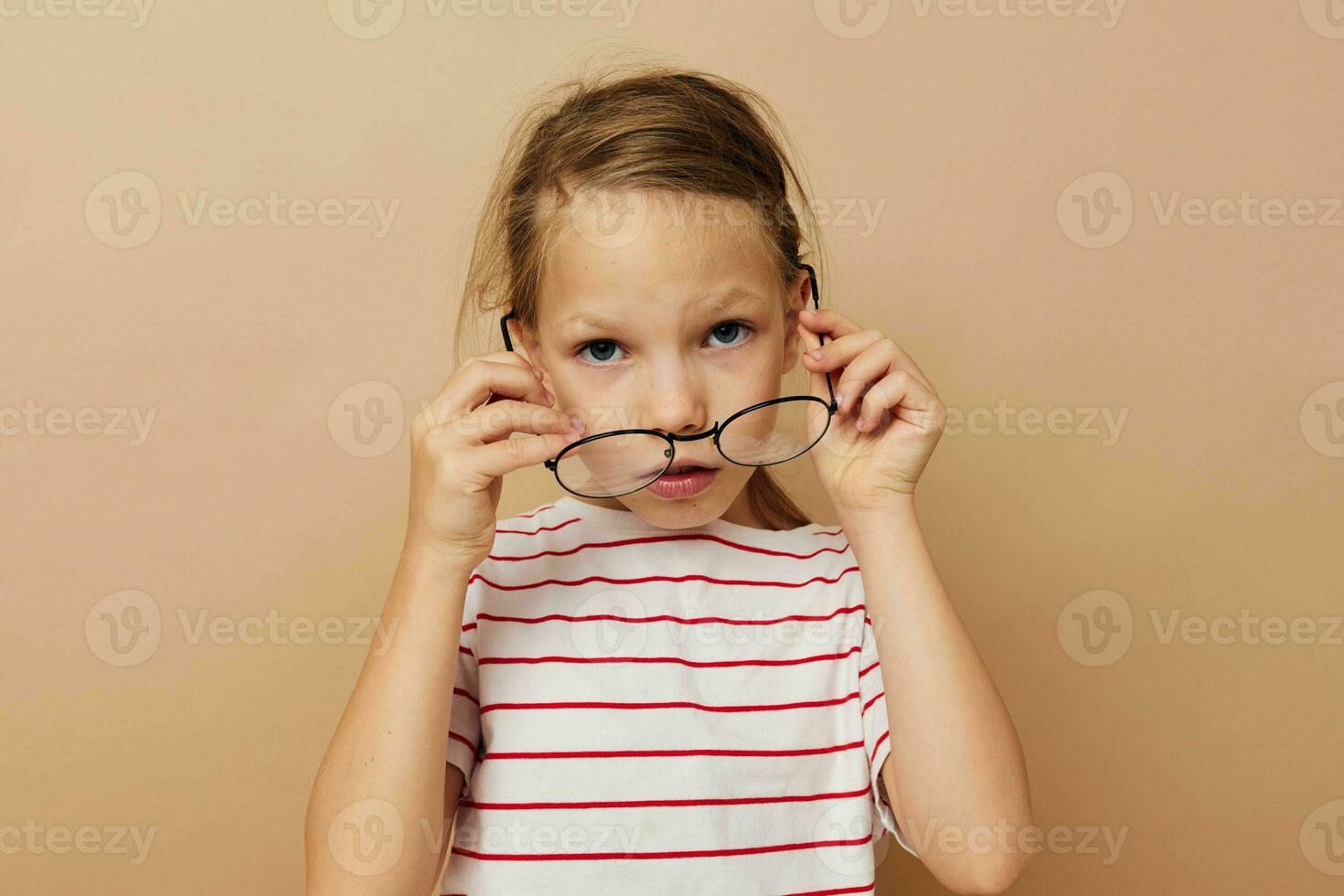 süß wenig Mädchen runden Brille posieren Beige Hintergrund foto