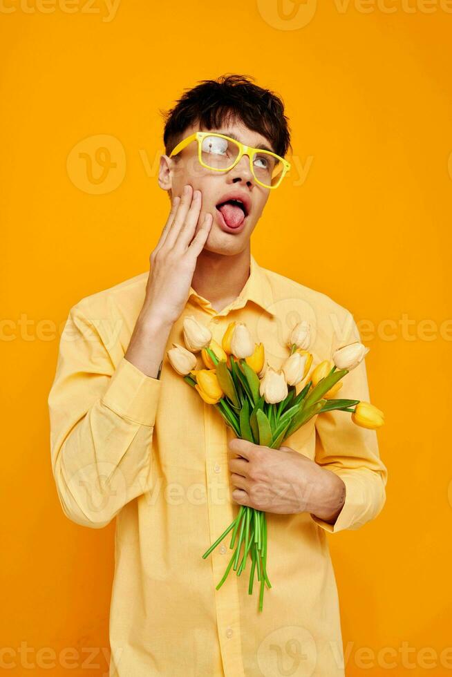 ein jung Mann mit ein Strauß von Blumen posieren ein Geschenk isoliert Hintergrund unverändert foto