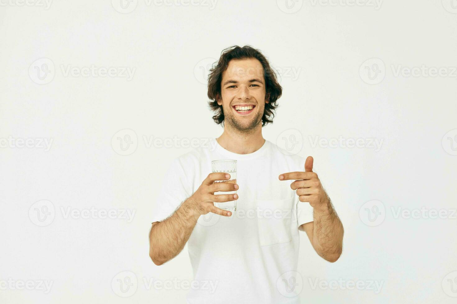 attraktiv Mann im ein Weiß T-Shirt Glas von Wasser isoliert Hintergrund foto