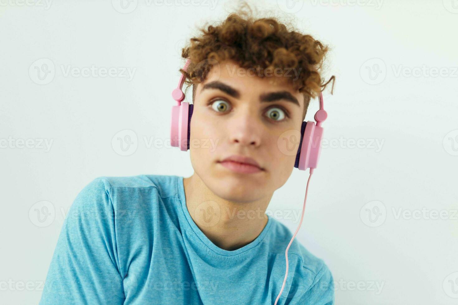 pervers Kerl im Blau T-Shirts Rosa Kopfhörer Mode Licht Hintergrund foto