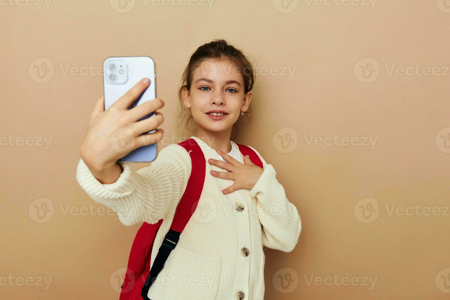 süß Mädchen Schülerin Rucksack Telefon im Hand isoliert Hintergrund foto
