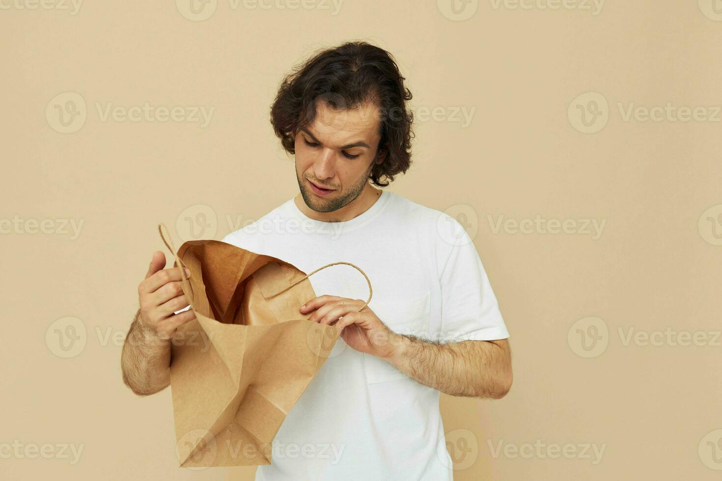 gut aussehend Mann Papier Tasche Emotionen posieren Lebensstil unverändert foto