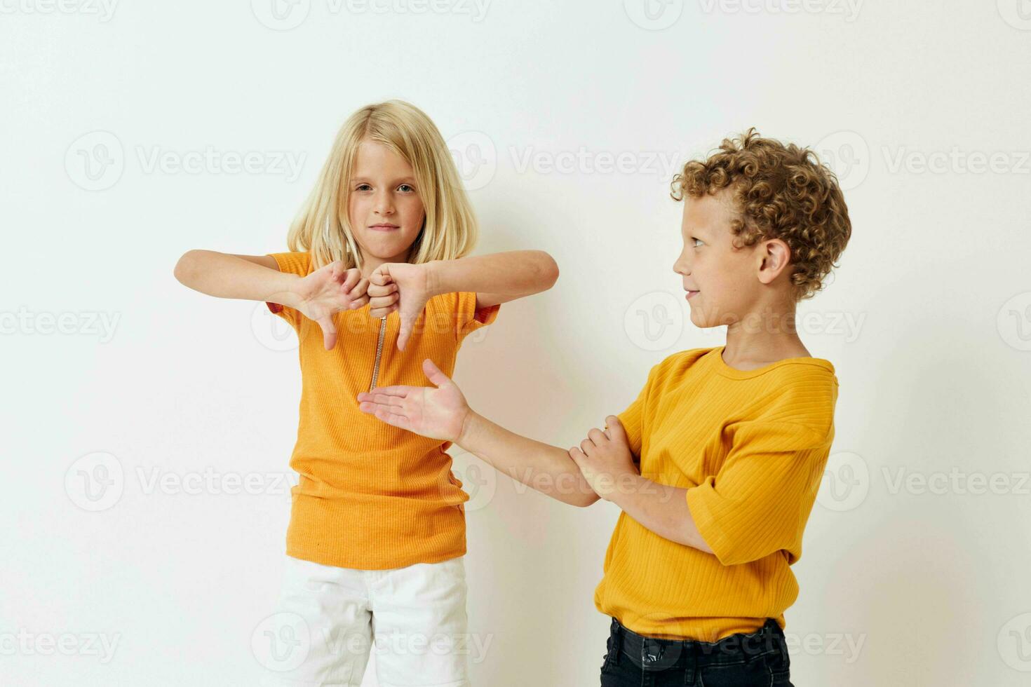 heiter Junge und Mädchen im Gelb T-Shirts posieren Studio foto