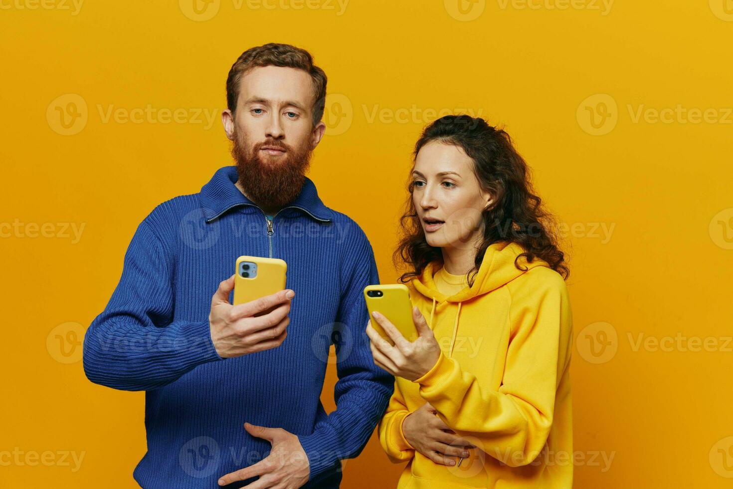 Mann und Frau Paar lächelnd fröhlich mit Telefon im Hand Sozial Medien Anzeigen Fotos und Videos, auf Gelb Hintergrund, Symbole Zeichen und Hand Gesten, Familie Freiberufler.