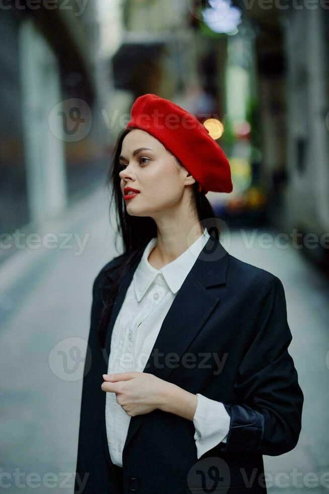 Mode Frau Lächeln mit Zähne Porträt Gehen Tourist im stilvoll Kleider im Jacke mit rot Lippen Gehen Nieder eng Stadt Straße fliegend Haar, reisen, filmisch Farbe, retro Jahrgang Stil. foto