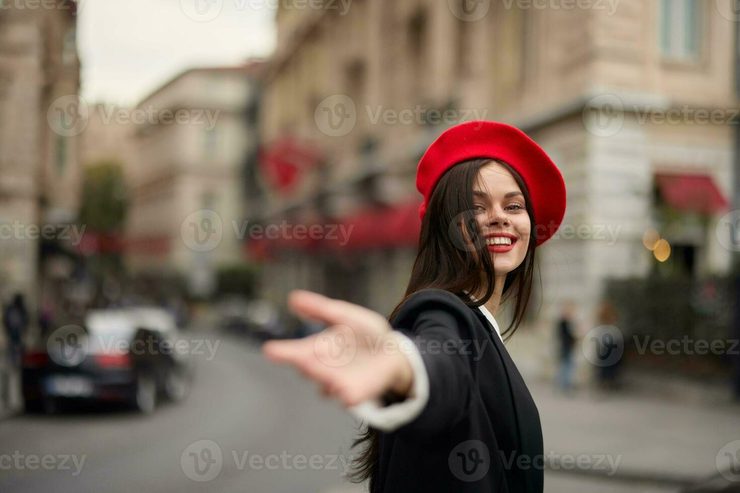 Mode Frau Lächeln mit Zähne Stehen auf das Straße im Vorderseite von das Stadt Tourist Folgen mich stilvoll Kleider mit rot Lippen und rot Baskenmütze, reisen, filmisch Farbe, retro Jahrgang Stil, städtisch Mode. foto