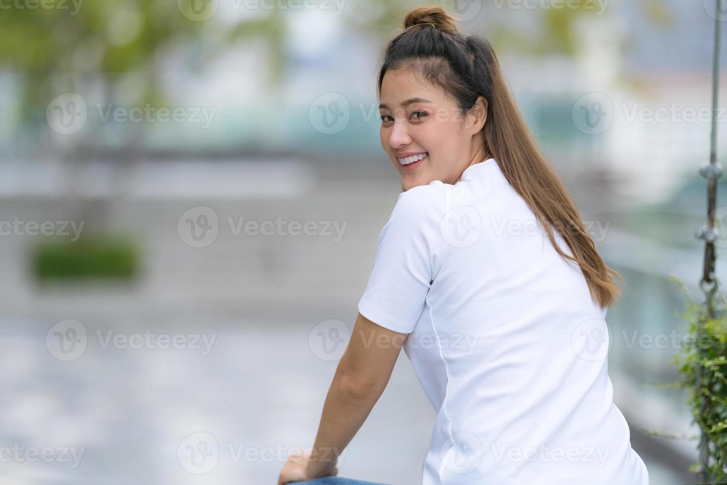 Frau im weißen T-Shirt und in den blauen Jeans foto