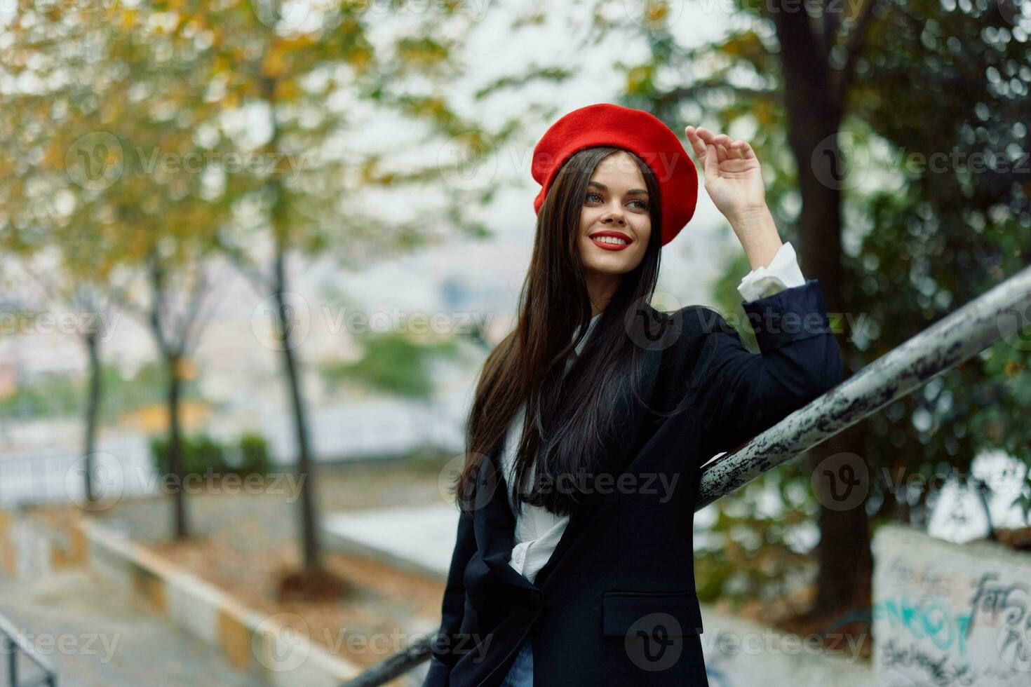 Mode Frau Gehen Nieder Schritte gegen Stadt Hintergrund im stilvoll Kleider mit rot Lippen und rot Baskenmütze, reisen, filmisch Farbe, retro Jahrgang Stil, städtisch Mode Lebensstil. foto