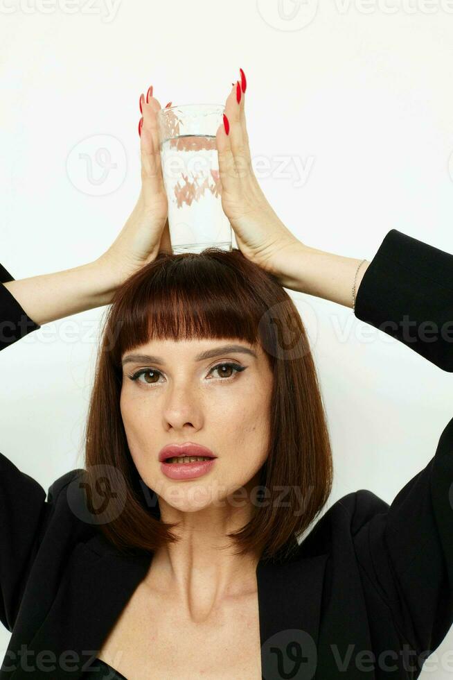 schön Frau schwarz Jacke transparent Glas mit Wasser isoliert Hintergrund foto