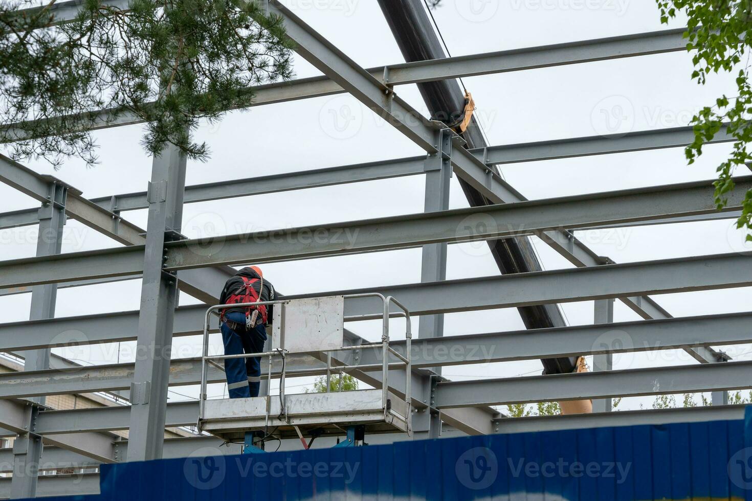 ein Konstruktion Arbeiter mit ein Sicherheit Gürtel zum Arbeiten beim Höhe foto