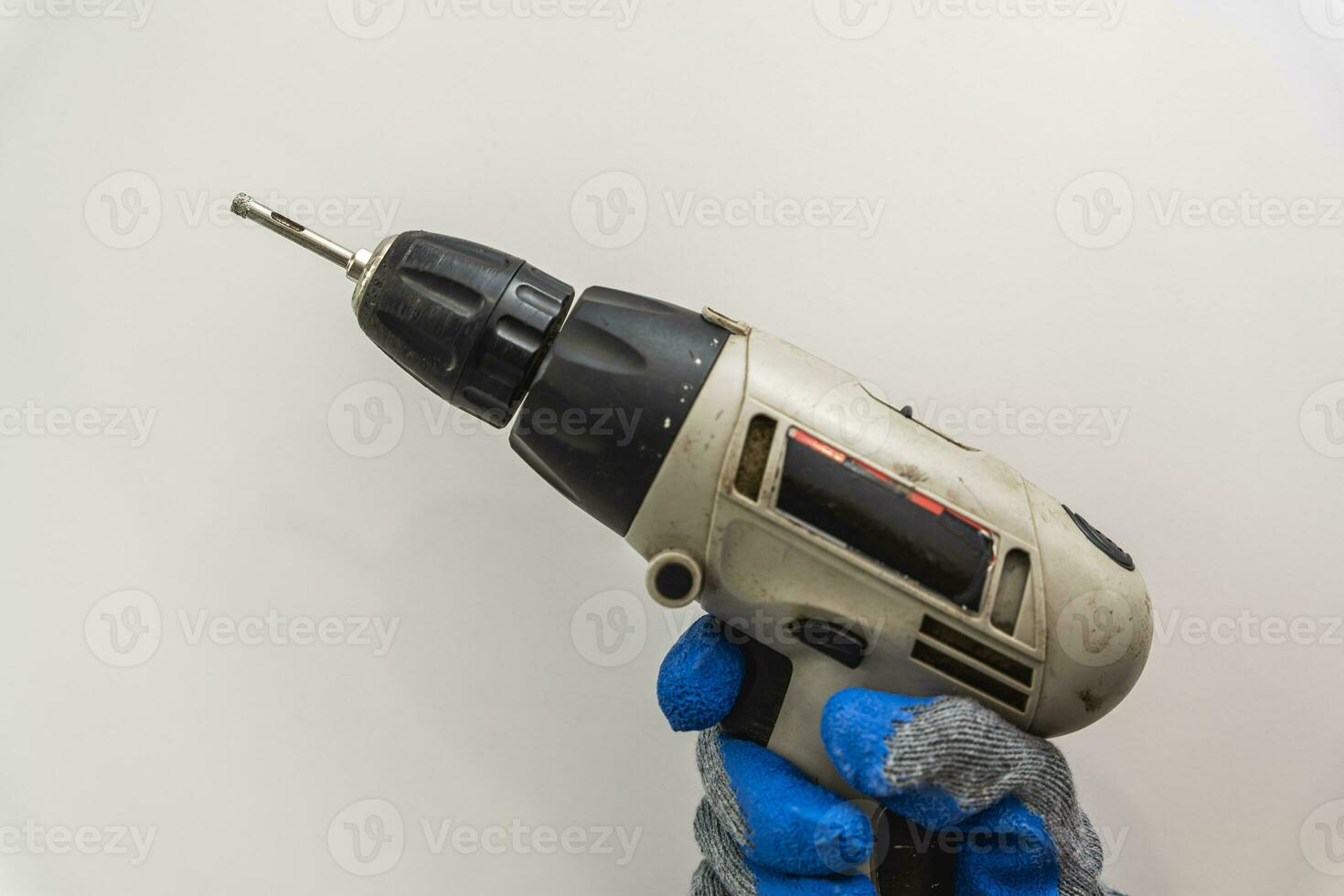 ein schnurlos Schraubendreher im das Hände von ein Mann im Arbeit Handschuhe foto