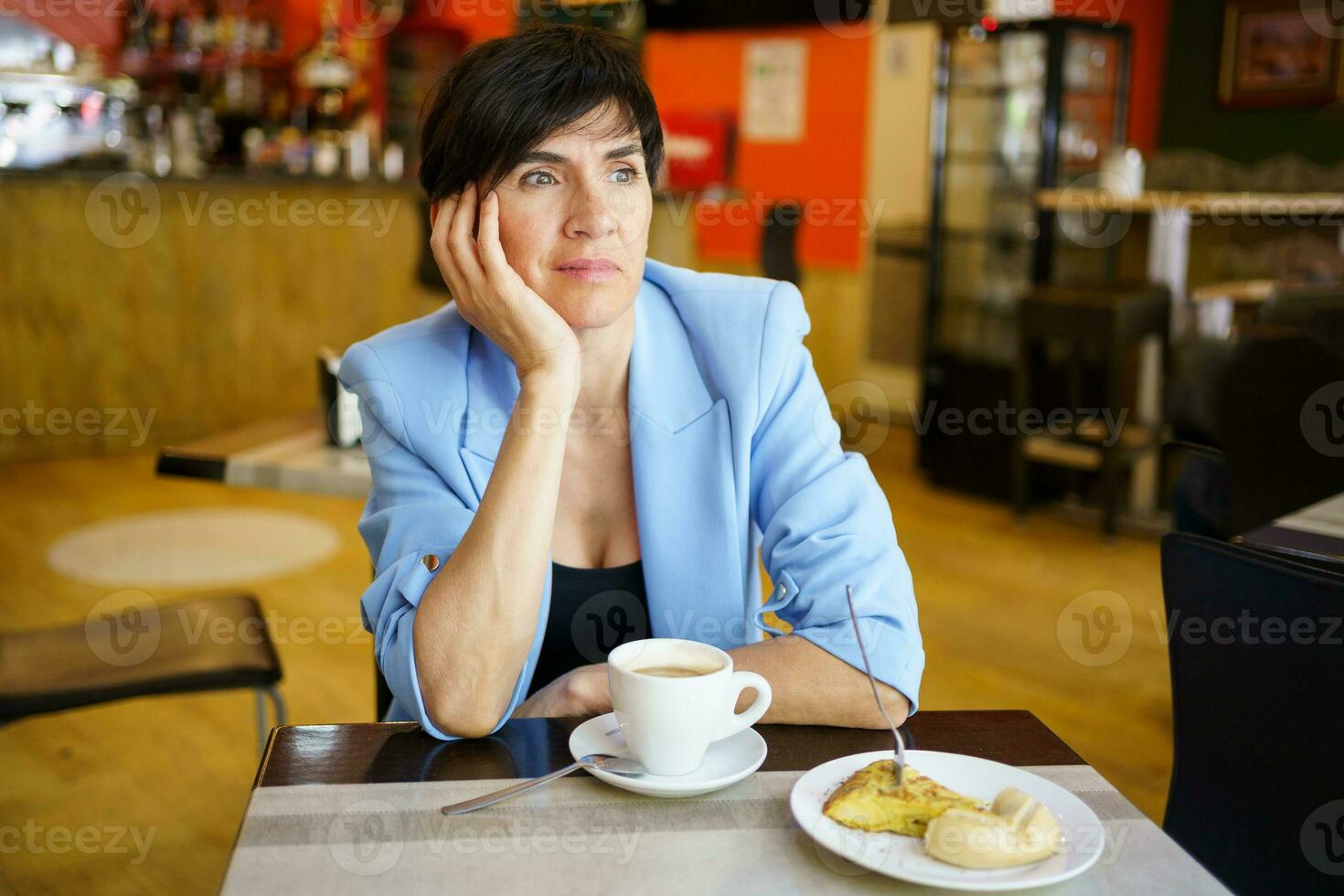 nachdenklich weiblich mit Tasse von Kaffee und Frühstück im Cafe foto