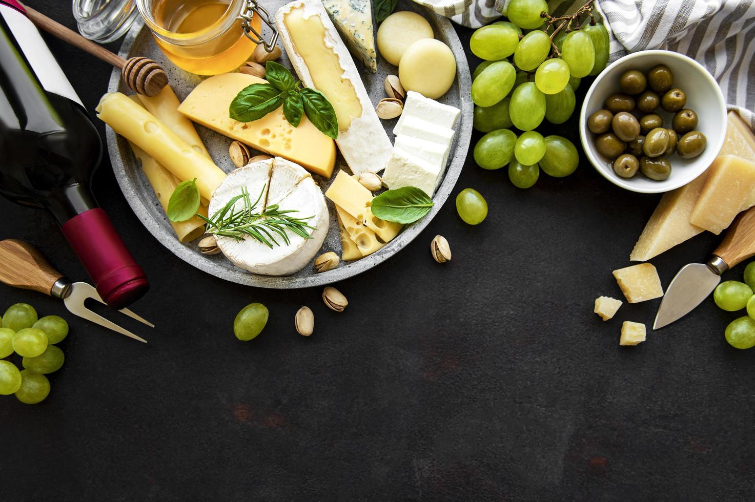 verschiedene Arten von Käse, Trauben, Wein und Snacks foto