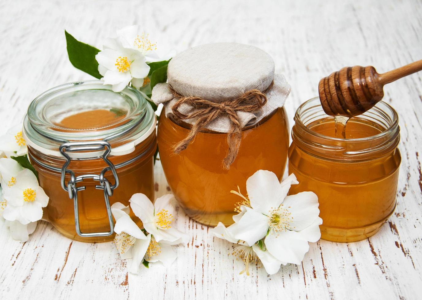 Honig mit Jasminblüten auf einem hölzernen Hintergrund foto