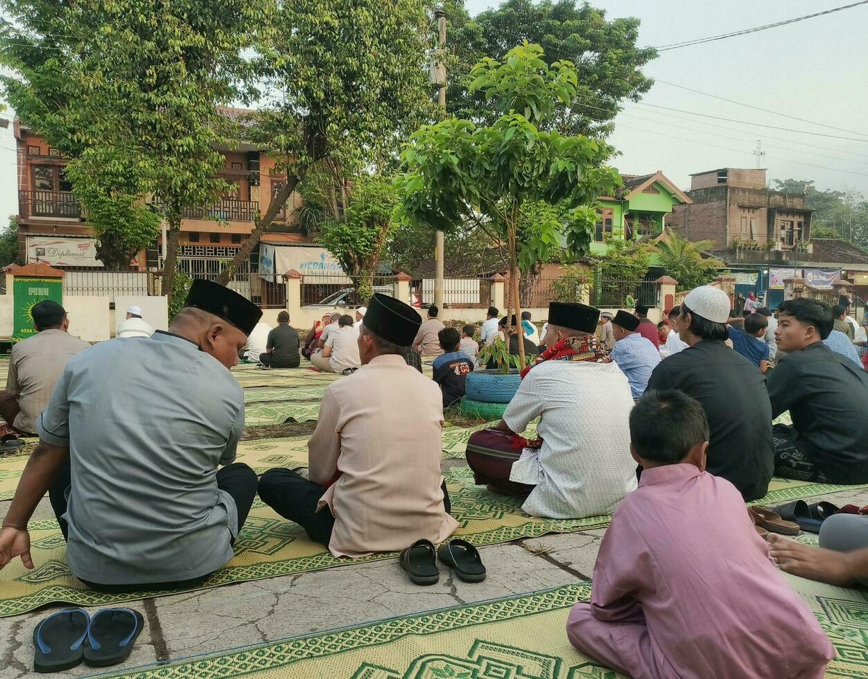 Solo - - April 22, 2023 - - Muslim Gemeinde Sitzung auf Matten warten zum das eid al-fitr Gebet zu Sein gehaltenen foto