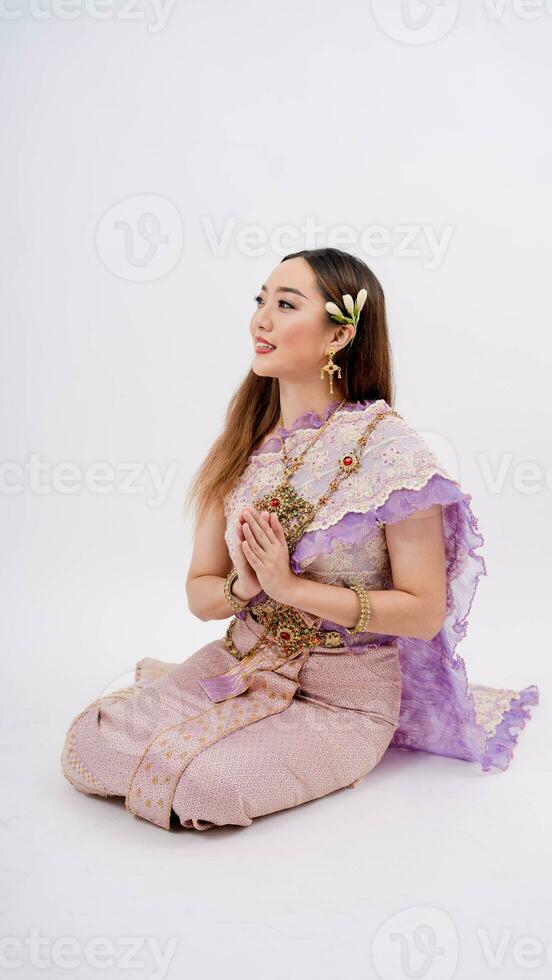 Dame tragen typisch thailändisch Kleid und posieren zu Zahlen Respekt mit lächelnd isoliert auf Weiß Hintergrund, Identität Kultur von Thailand foto