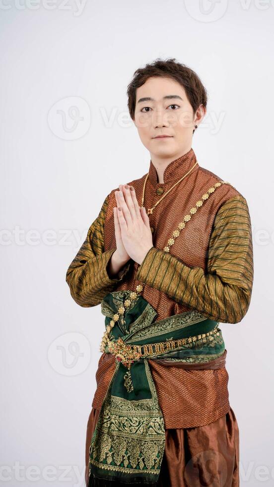 asiatisch Mann tragen typisch, traditionell thailändisch Kleid mit Identität thailändisch Kultur posieren zu Zahlen Respekt mit lächelnd isoliert auf Weiß Hintergrund foto