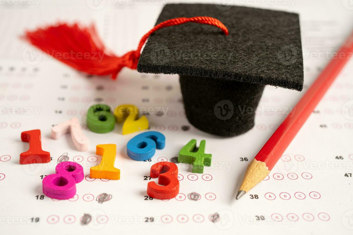 Abschluss Spalt Hut und Bleistift auf Antworten Blatt Papier, Bildung Studie testen Lernen lehren Konzept. foto