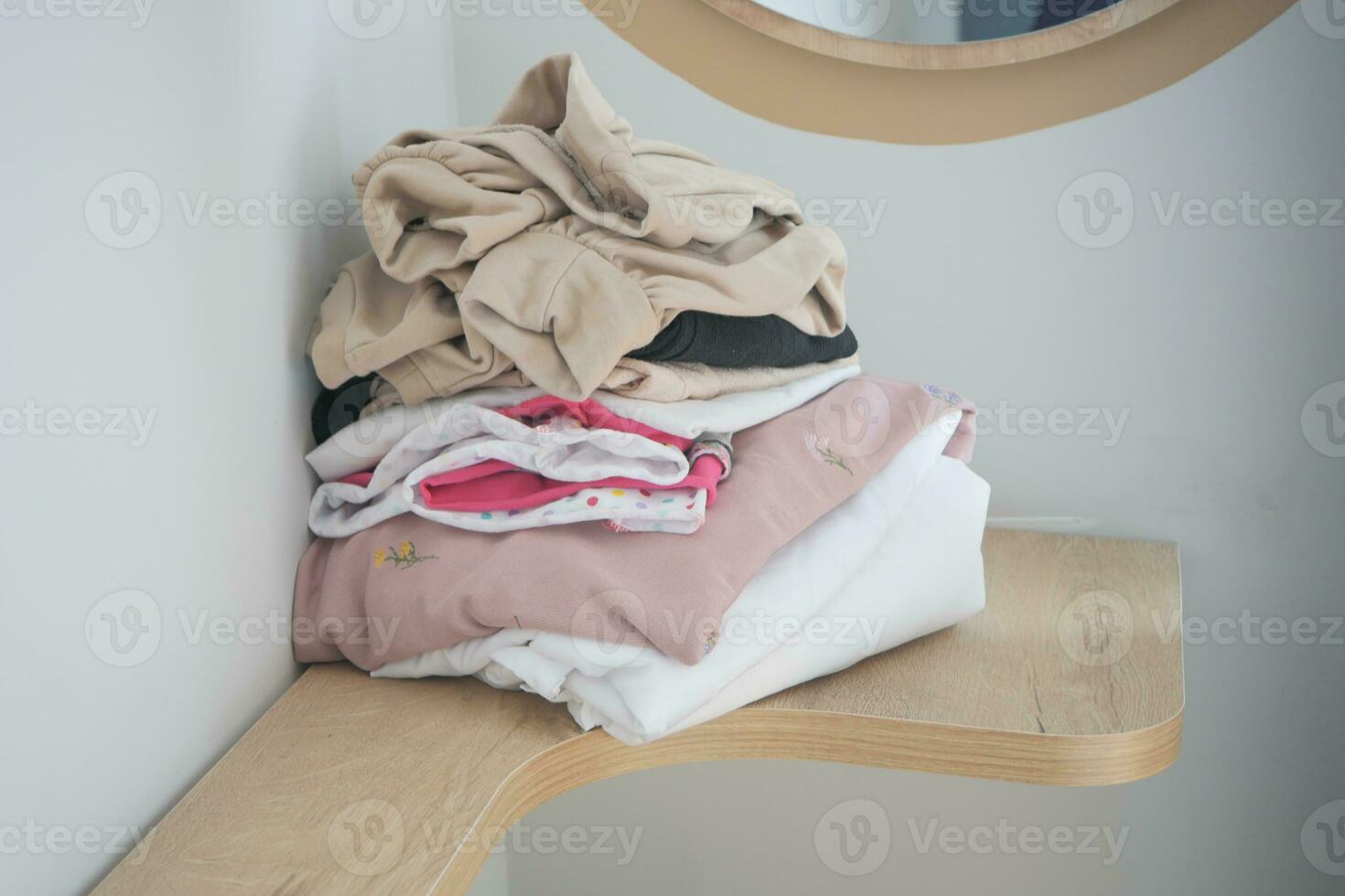 Stapel von Kleider auf Tabelle drinnen. foto